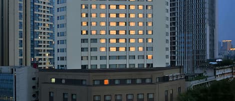 A high-rise hotel with multiple floors, illuminated windows, and a prominent signage.