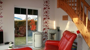 Quarto com um sofá de couro vermelho, um armário branco e uma escada de madeira.