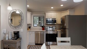 A compact kitchen with white cabinets, stainless steel appliances, a microwave, oven, and a refrigerator. - Labor Day Special! 2 bd/2 bath! 3 Pools-Walk to Beach (Hilton Head Island)