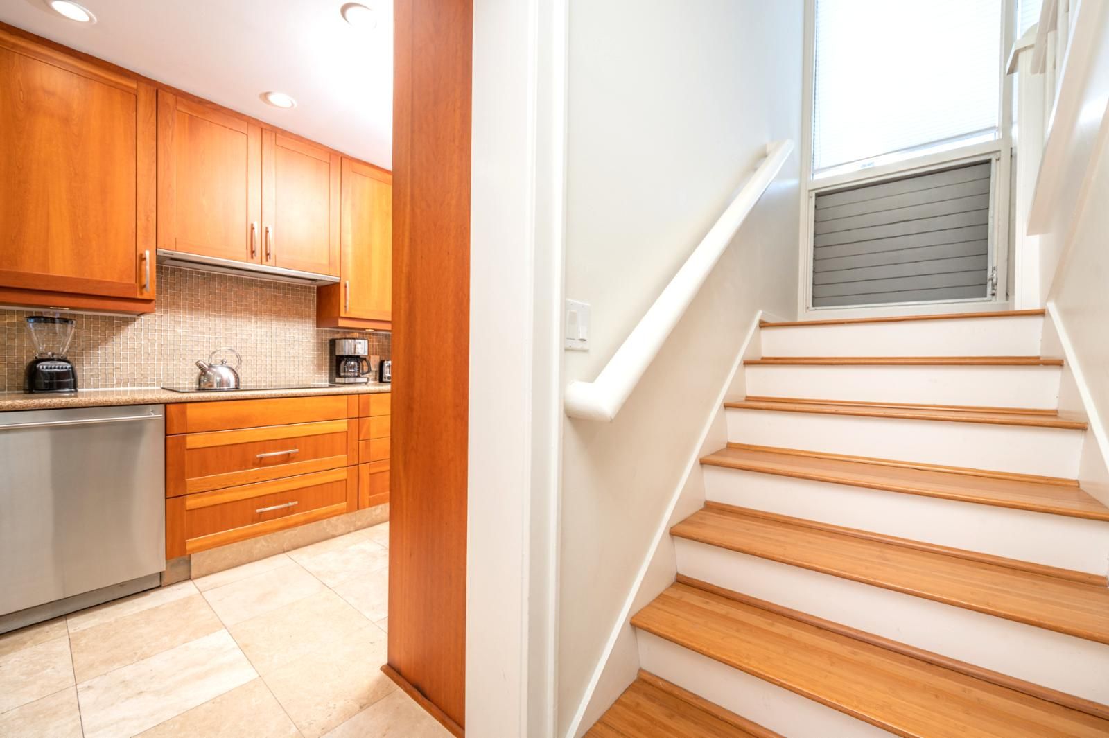 Una cocina moderna con armarios de madera y un refrigerador de acero inoxidable.