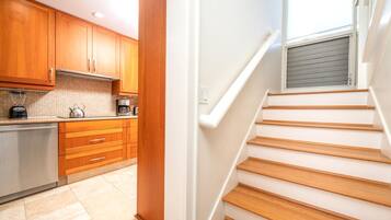Una cocina moderna con armarios de madera y un refrigerador de acero inoxidable.