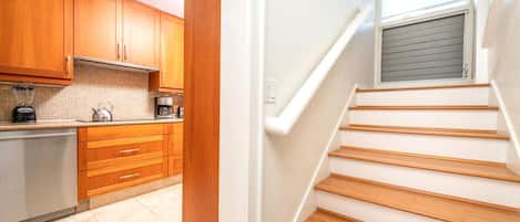 A modern kitchen with wooden cabinets and a stainless steel refrigerator.