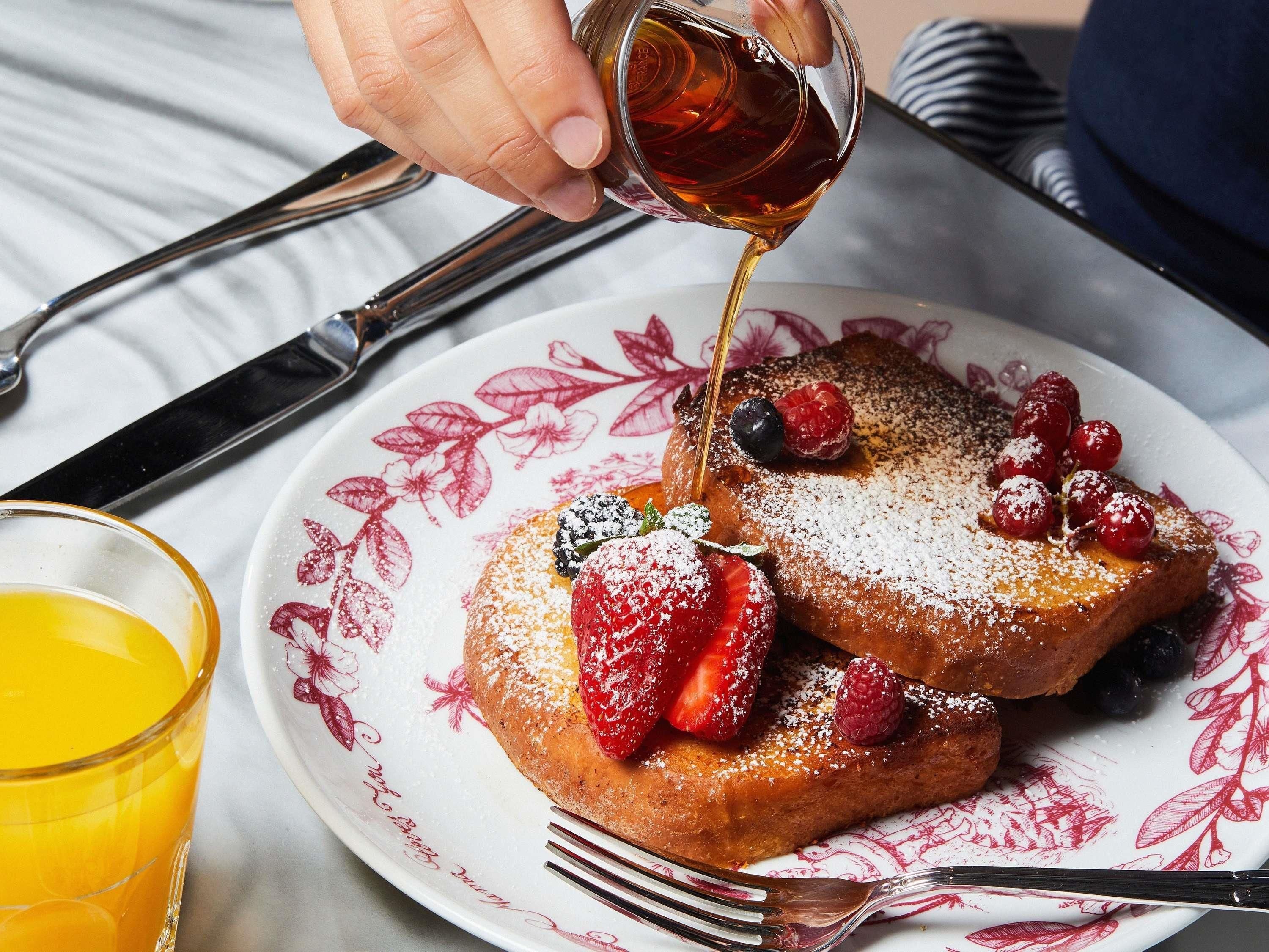 A breakfast plate with French toast, berries, and syrup.