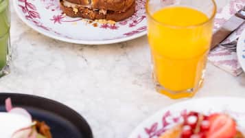 Una colazione con un piatto di cibo, un bicchiere di succo d'arancia e una tovaglietta.