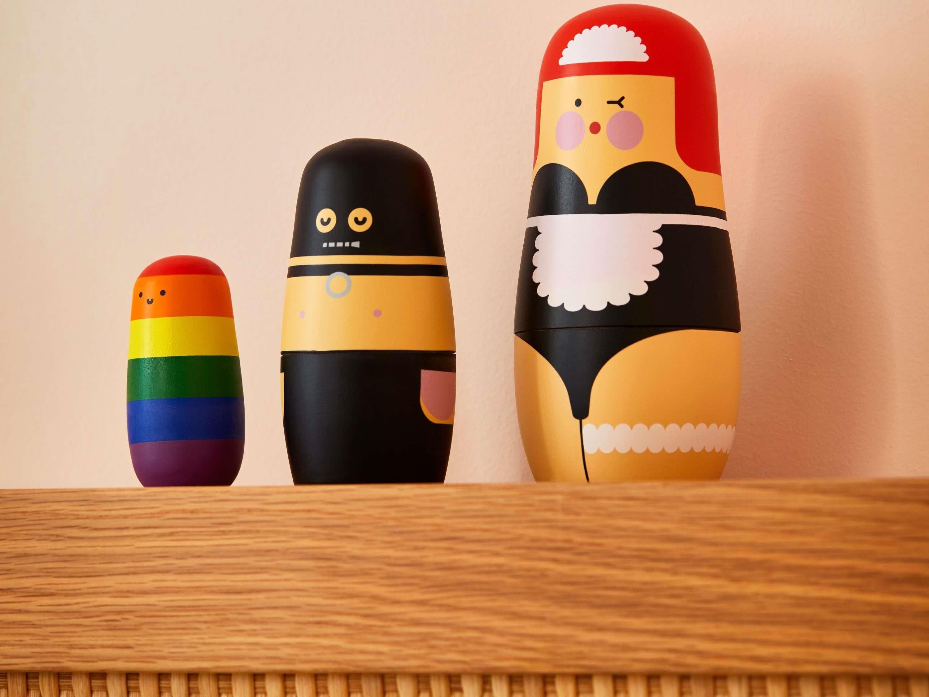 Three colorful, uniquely decorated objects on a wooden surface.