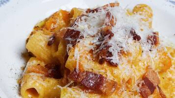 A plate of pasta with cheese and bacon.