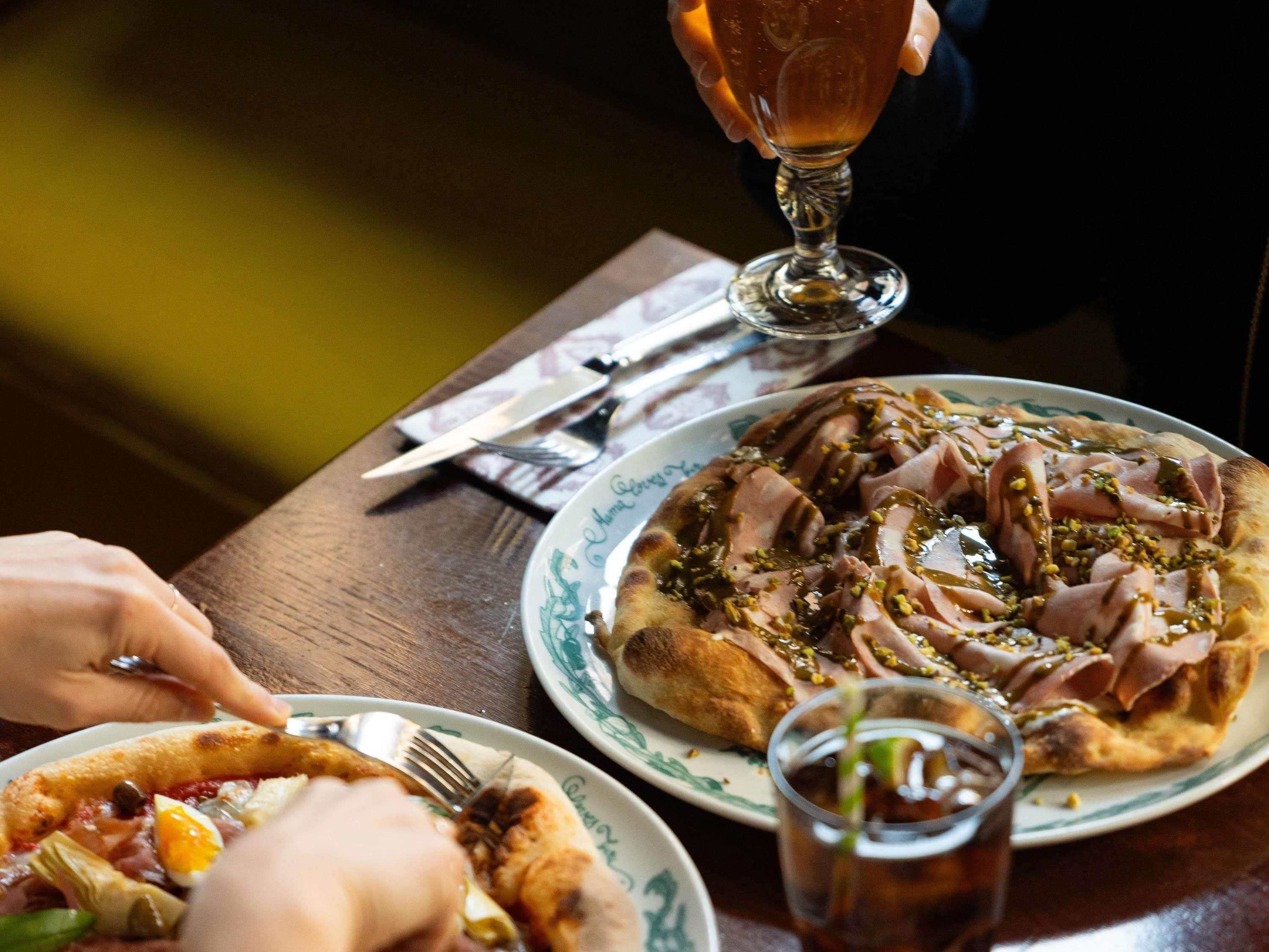 Une table à manger avec des assiettes remplies de nourriture, un verre et des couverts.