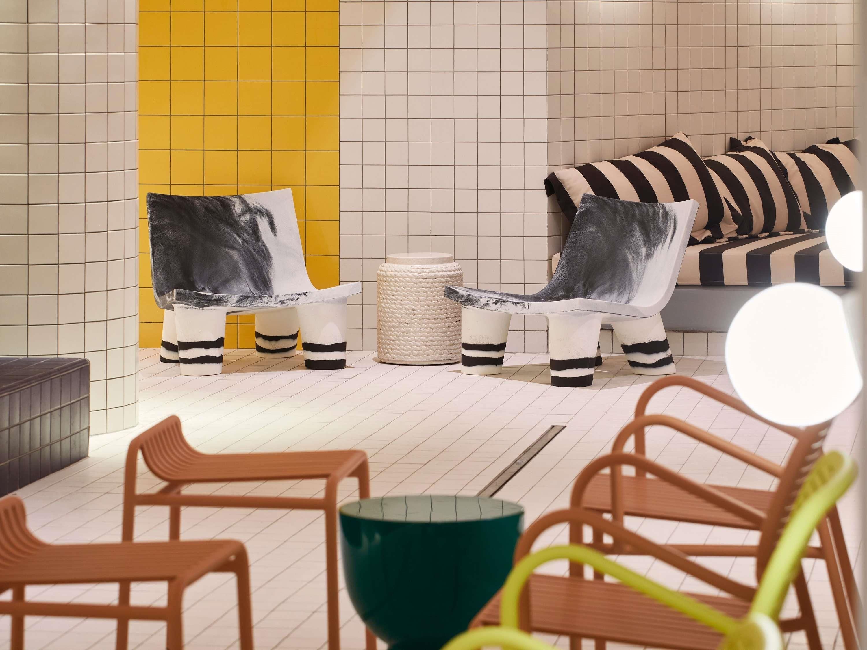 Ein modernes Interieur mit einer Couch, Stühlen, einem Tisch und einer dekorativen Schale.
