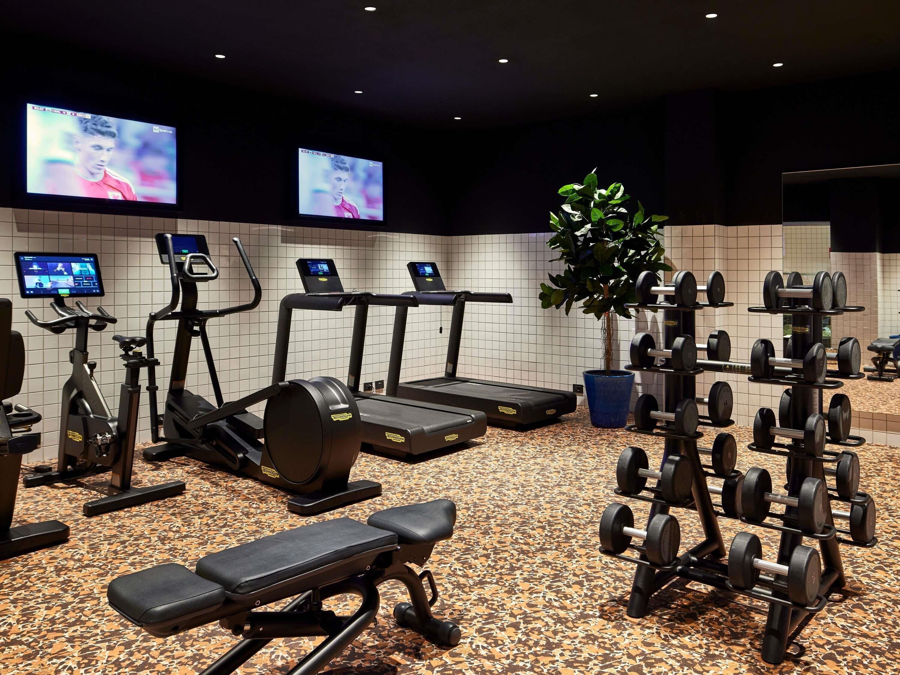 A gym with treadmills, an elliptical, a bench, and weight machines.