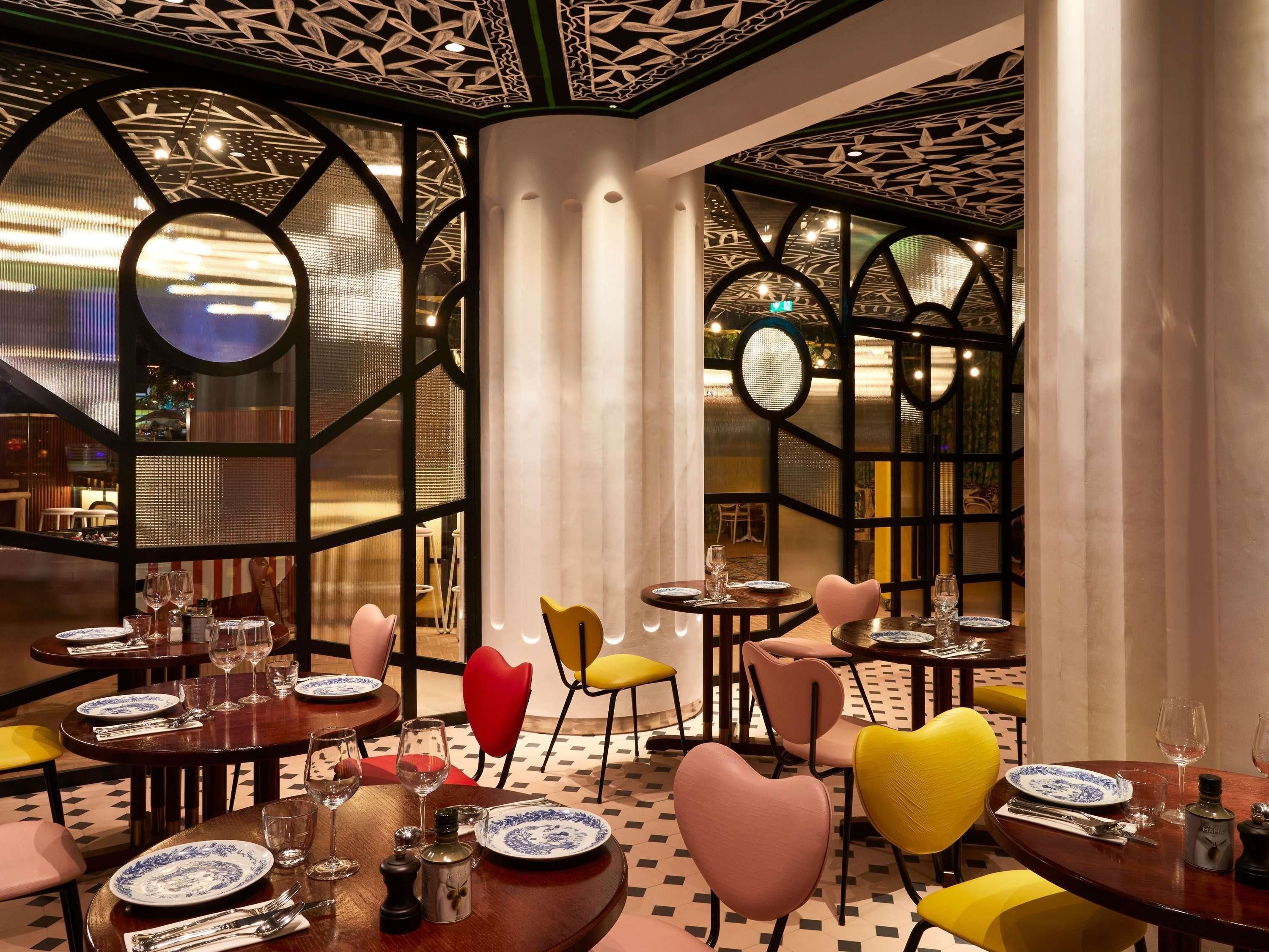 Un ristorante con tavoli rotondi, sedie a forma di cuore e un pavimento decorato.