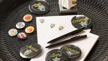 A tray with various items including name badges, a pen, and a small figurine.