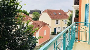 Un quartier résidentiel où les maisons se distinguent par leurs toits recouverts de tuiles rouges et leurs façades aux couleurs pastel.