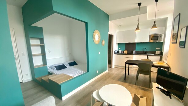 Un appartamento moderno con una zona giorno accogliente, una cucina e un'area pranzo.