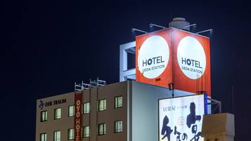 A hotel with signage indicating 'HOTEL UEDA STATION' and a sign with Japanese characters.