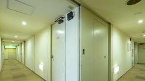 Ein Hotelkorridor mit mehreren Türen, jede mit einer Nummer versehen.