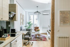 Een moderne keuken met een eethoek, een groot raam en uitzicht op de stad.