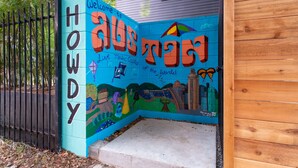 Een kleurrijke muurschildering met de tekst 'Welcome to Hoedy' en 'Live music Capital of the 2nd World'.