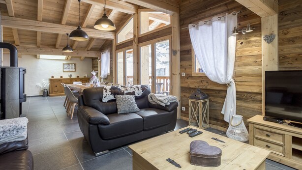 Un intérieur chaleureux en bois, avec un canapé, une télévision et un coin repas.