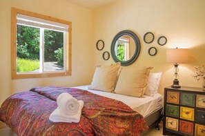Relax in a serene bedroom with a large bed, circular mirrors, and a dresser featuring unique bird designs.