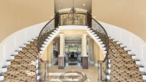A grand staircase with a patterned carpet, a chandelier, and a view into a spacious living area. - * NEW Luxury Celebrity Vineyard Estate Temecula * (Murrieta)