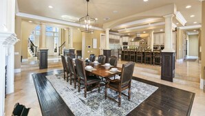 A spacious dining area with a large wooden table, multiple chairs, and a chandelier. - * NEW Luxury Celebrity Vineyard Estate Temecula * (Murrieta)