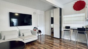 En moderne stue med sofa, sofabord og spiseplads med stole.