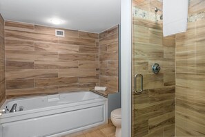 Ein Badezimmer mit Badewanne, Toilette und Duschbereich.