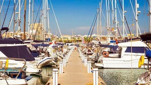 Un puerto deportivo con numerosos barcos amarrados a lo largo de un muelle de madera.