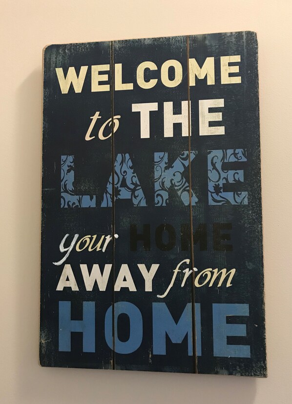 Une pancarte d’accueil avec le texte suivant : « BIENVENUE au bord du LAC, votre deuxième maison. »
