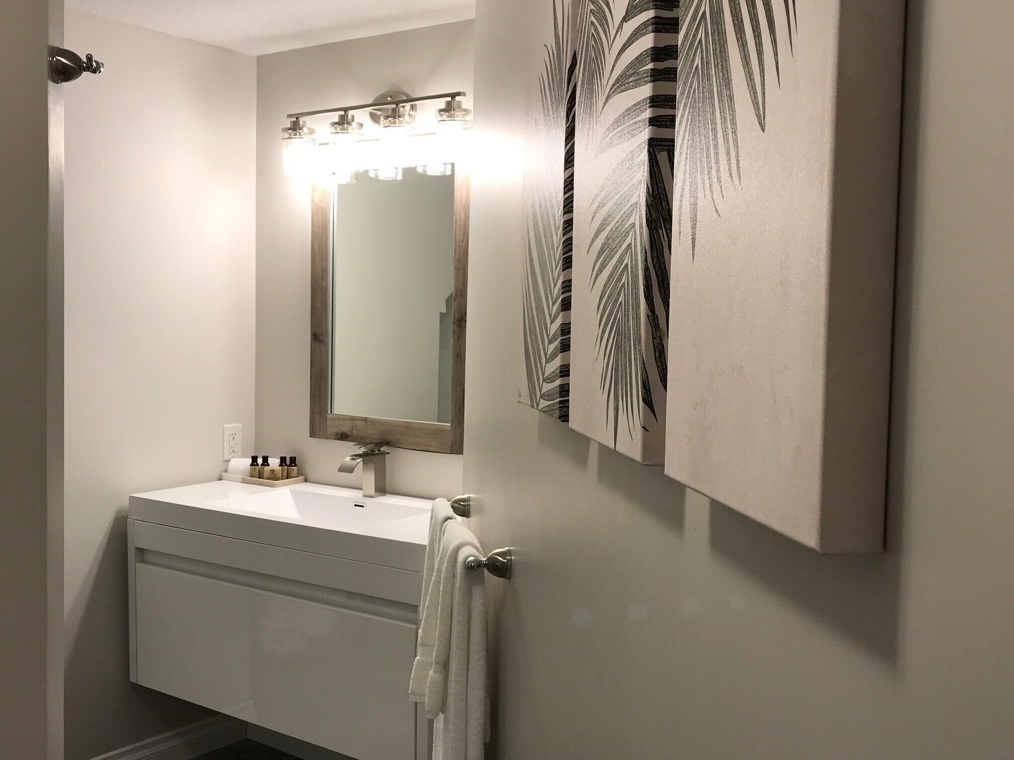 A bathroom with a white sink, a mirror, and a towel rack.