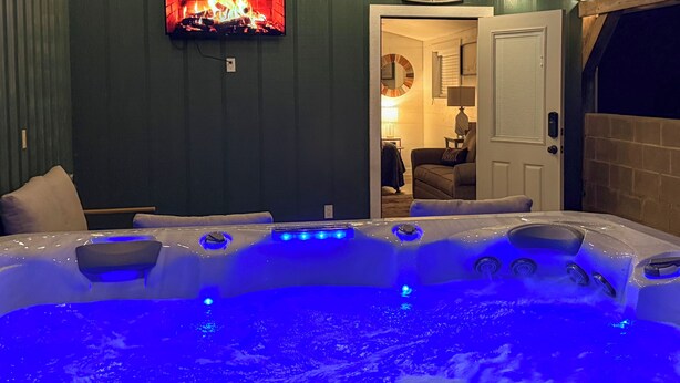A room with a hot tub, a fireplace, and a 'Welcome to the Farm' sign. - Barnside Hangout - Ranch Retreat - Master Spa - Hot Tub - Near Fredericksburg (Fredericksburg)