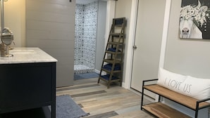 A bathroom with a white sink, a mirror, a towel rack, a wooden ladder, and a door with a white pillow that says "I LOVE US." - Barnside Hangout - Ranch Retreat - Master Spa - Hot Tub - Near Fredericksburg (Fredericksburg)