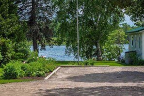 Guests can enjoy a serene lakeside view from this property, surrounded by lush greenery and a short walk to the water's edge.