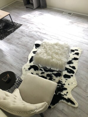 Relax in a stylish space with a comfortable leather armchair, a plush rug, and a functional side table.