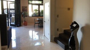 Un interno moderno con zona pranzo, una scala e un'ampia finestra.