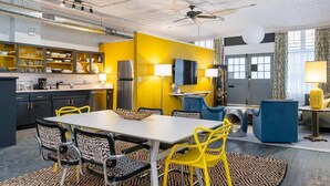 A modern kitchen with yellow walls, black and yellow chairs, and a dining table. - 35 Carolina Lane  Loft Downtown on Historic Alley + One Free Off Street Parking (Asheville)