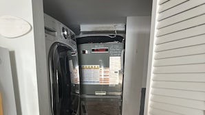 Une buanderie équipée d’un lave-linge, d’un sèche-linge et d’appareils électroménagers superposés.