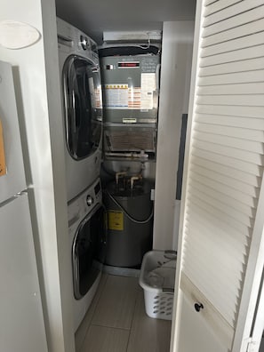 A laundry room with a washer, dryer, and stacked appliances.