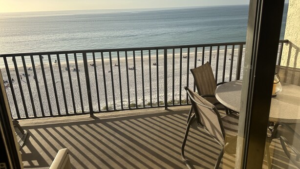 Un balcon avec vue sur la plage et l’océan.