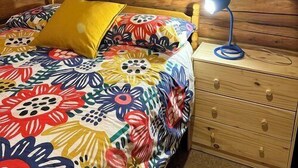 Acogedora habitación tipo cabaña de madera con una cama, una mesita de noche y una lámpara.