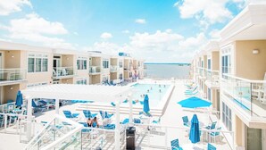 A cruise ship deck with multiple swimming pools, sun loungers, and a clear view of the sea. - Luxury water-view condo with high-end finishes and beach toys included! (Dewey Beach)