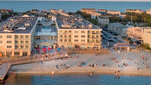 A beachside hotel with multiple buildings, a boardwalk, and a sandy beach. - Luxury water-view condo with high-end finishes and beach toys included! (Dewey Beach)