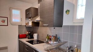A modern kitchen with dark wooden cabinets, a stainless steel sink, and a coffee maker.
