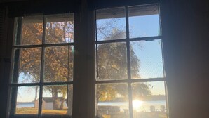 A window with a view of trees and a body of water. - Kawartha Lakes Cottage (Lakefield)