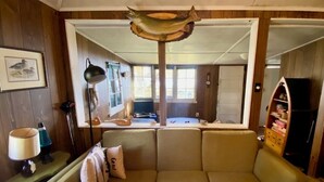 A cozy living room with a sofa, a lamp, and a fish hanging from the ceiling. - Kawartha Lakes Cottage (Lakefield)