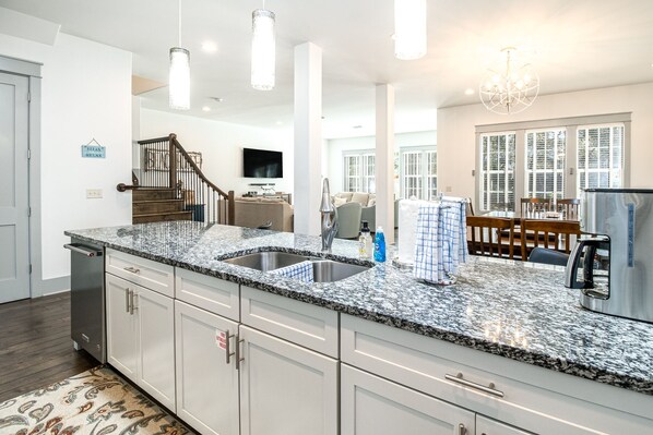 A modern kitchen with granite countertops, stainless steel appliances, and a built-in dishwasher. - Sugar Sand & Sea - Pool, Spa, Private Beach Access (Destin)