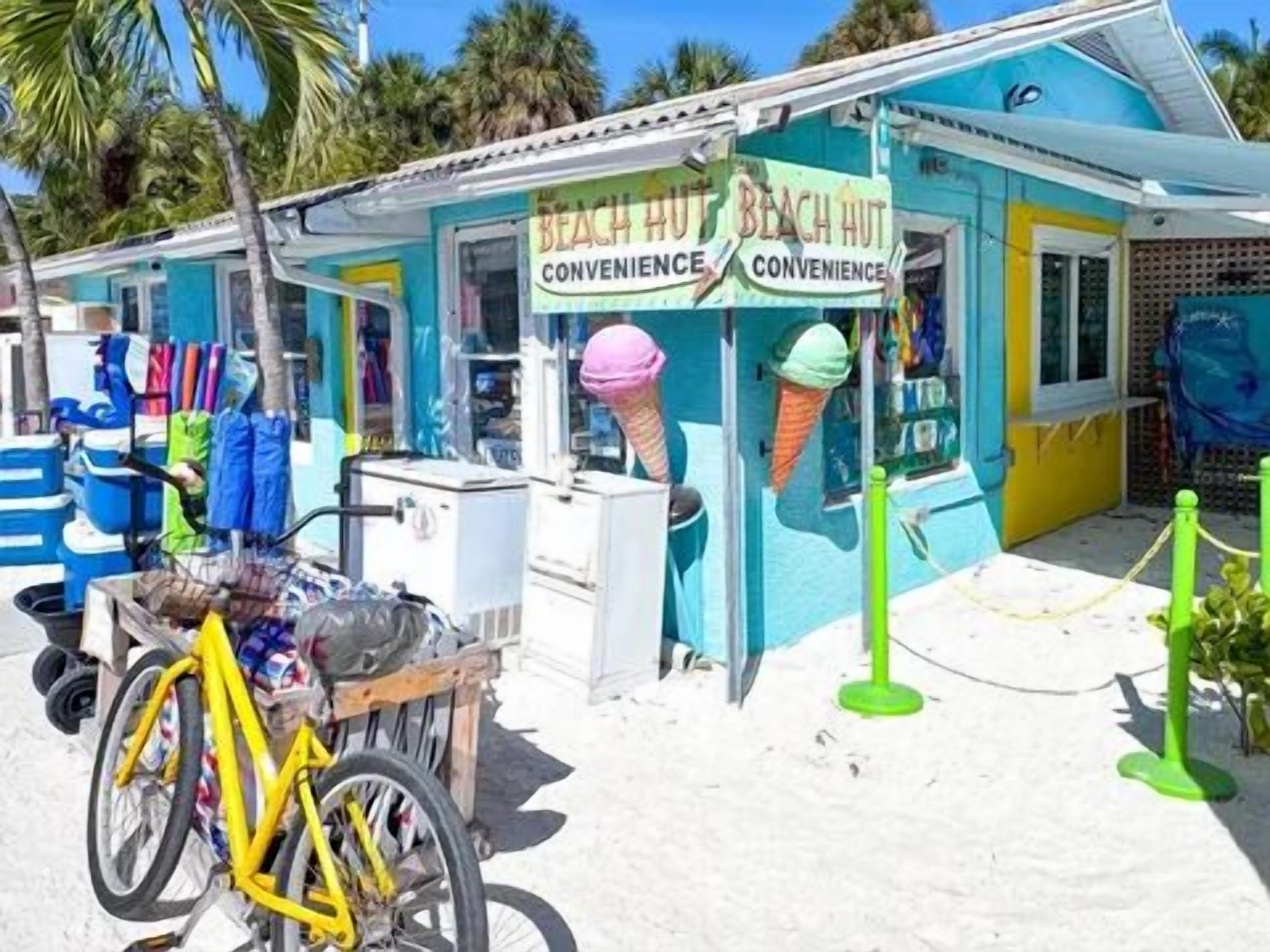 Una cabaña en la playa con un letrero que dice "Beach Hut Convenience".