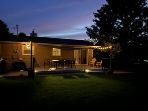A house with a covered patio, outdoor seating, and a swimming pool. - Relaxing Family Home (Rapid City)