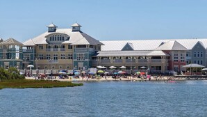 A waterfront hotel with multiple balconies and a beach area with umbrellas.