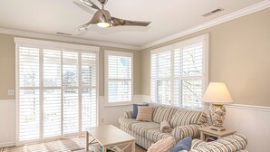 A living room with striped sofas, a coffee table, and a lamp.
